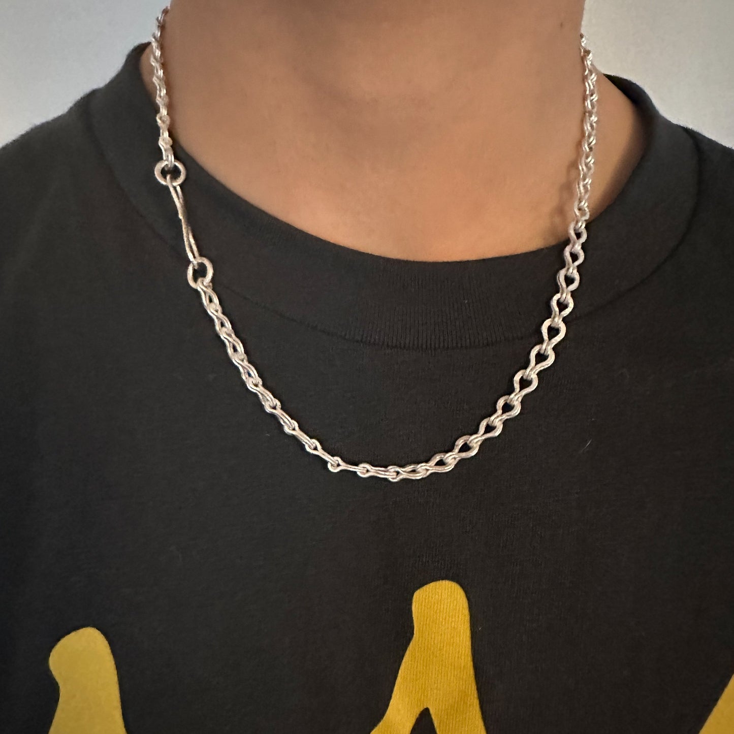 youngster wearing the dine silver Roman chain