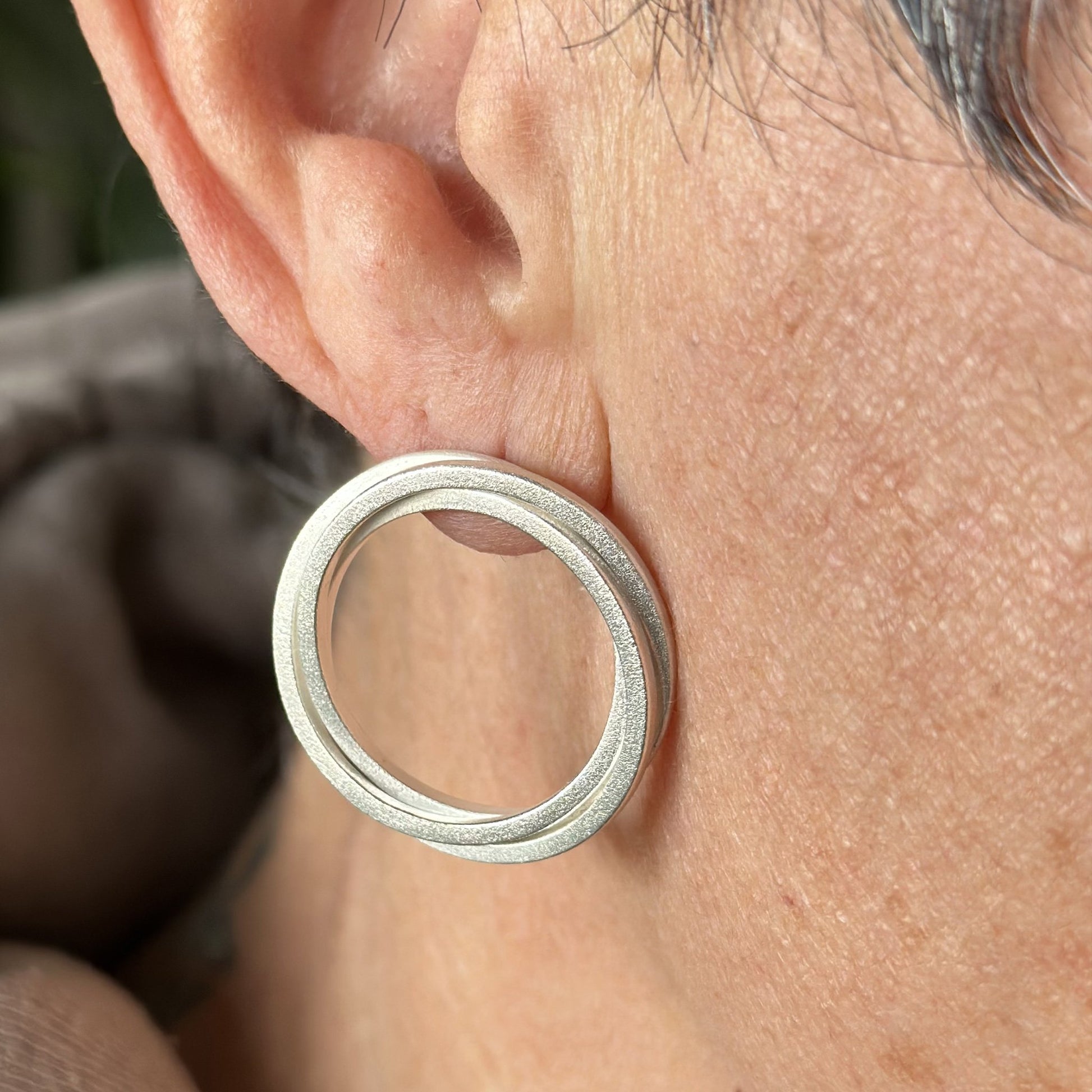 vortex earrings on woman